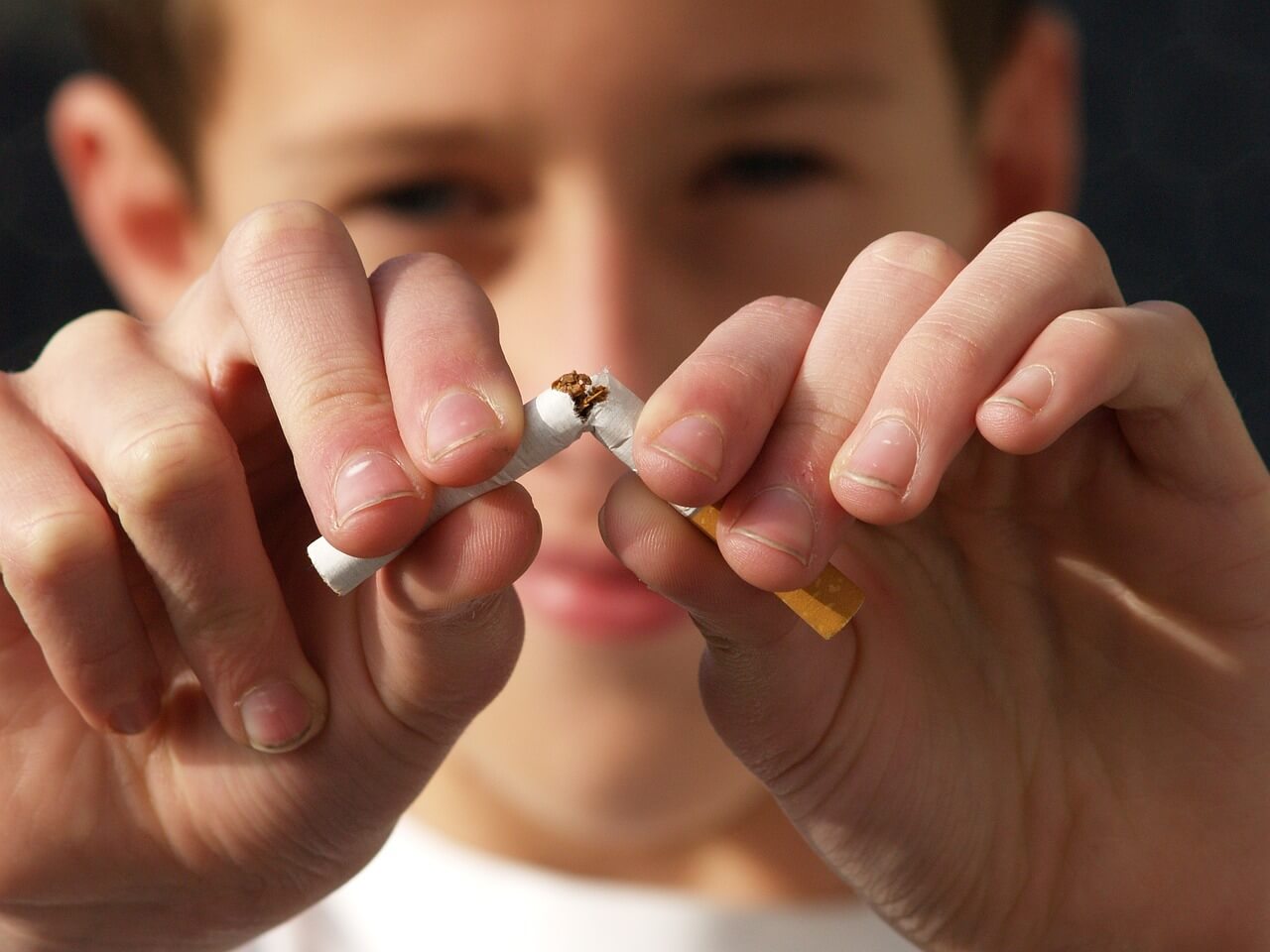 Pojke som knäcker en cigarett på mitten inför Tobaksfria dagen 2023
